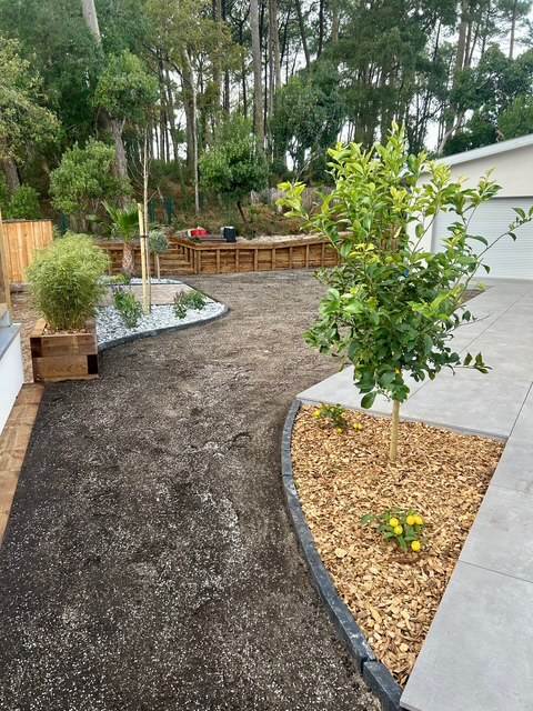Terrain en friche avant aménagement paysager, en bordure de maison neuve avec clôture en bois